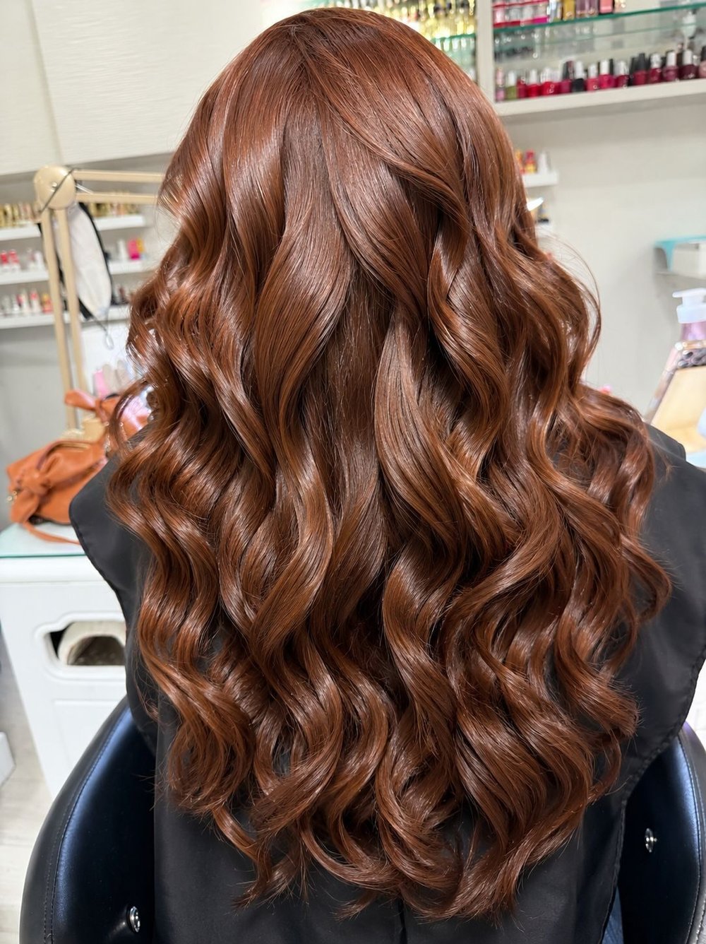 Long auburn hair styled in loose waves