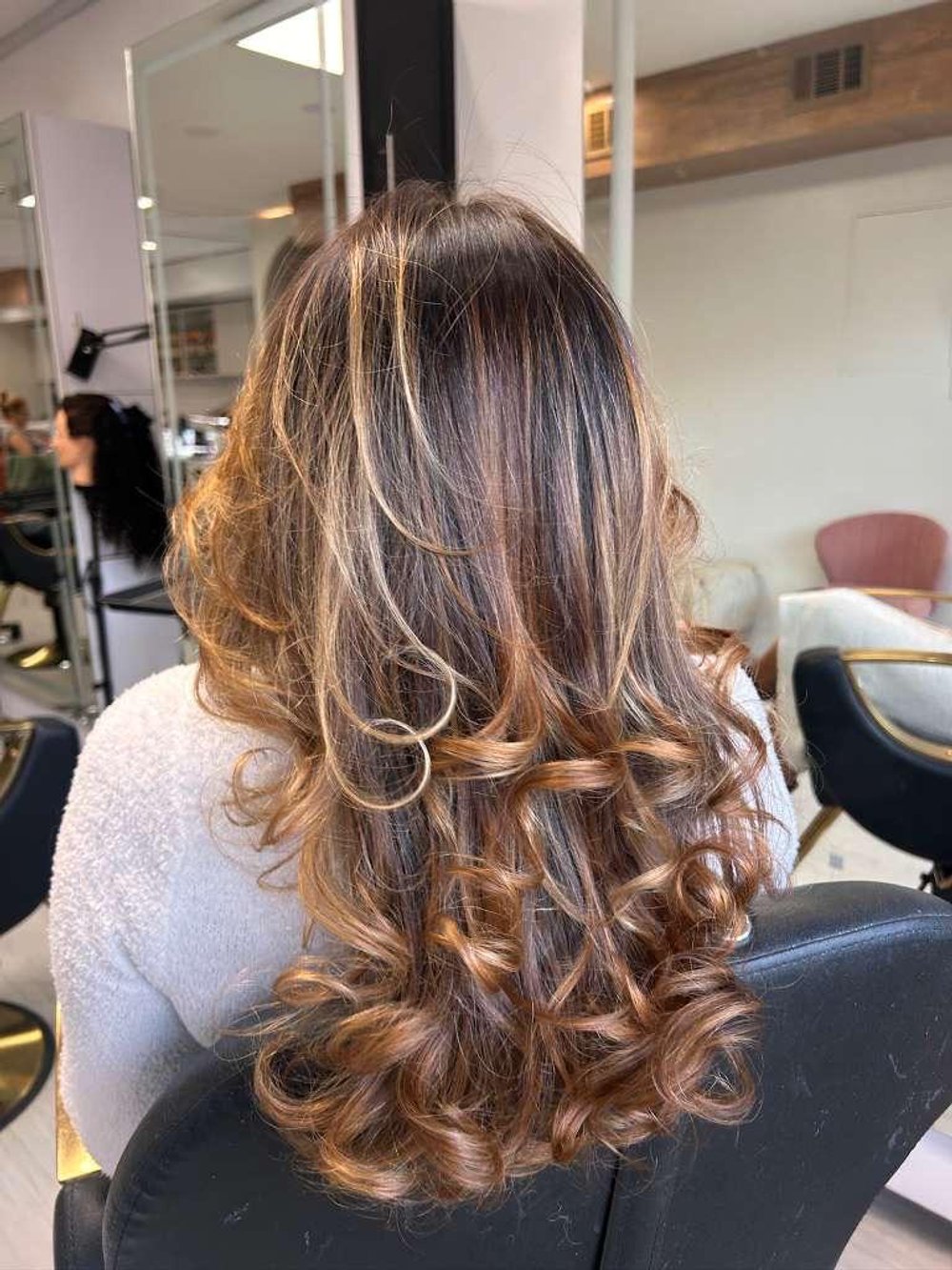 Caramel highlights with defined curls at Lush Atelier
